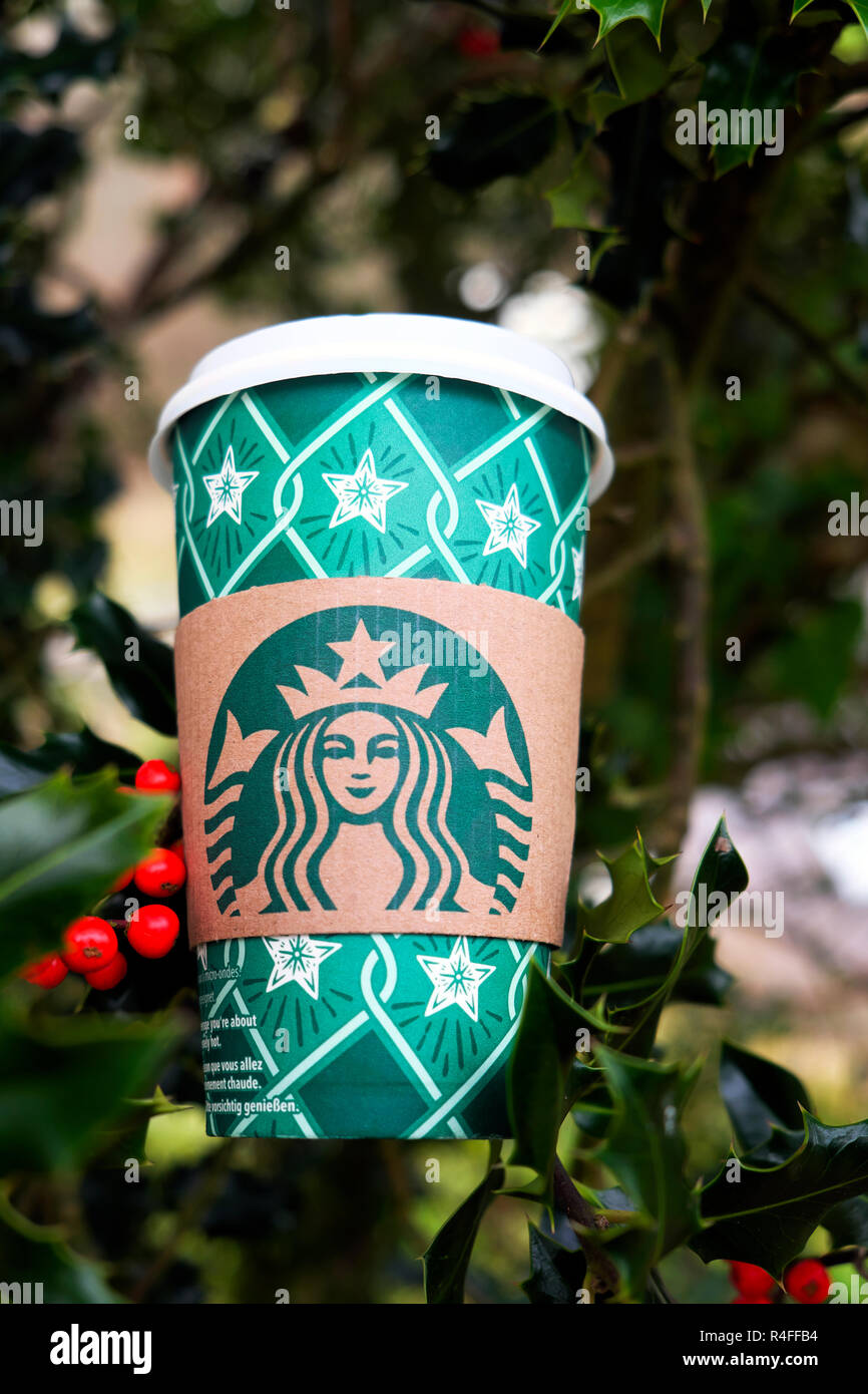 Noël Starbucks tasse de café en papier festif et baies de houx rouges dans arbre de houx Angleterre Grande-Bretagne Royaume-Uni KATHY DEWITT Banque D'Images