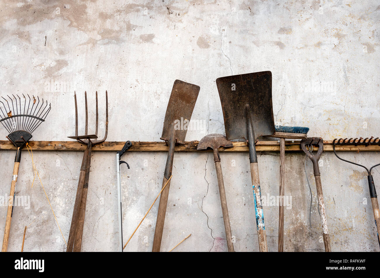 Une collection de divers outils de jardin rouillés d'occasion accrochés à  un mur abîmé Photo Stock - Alamy