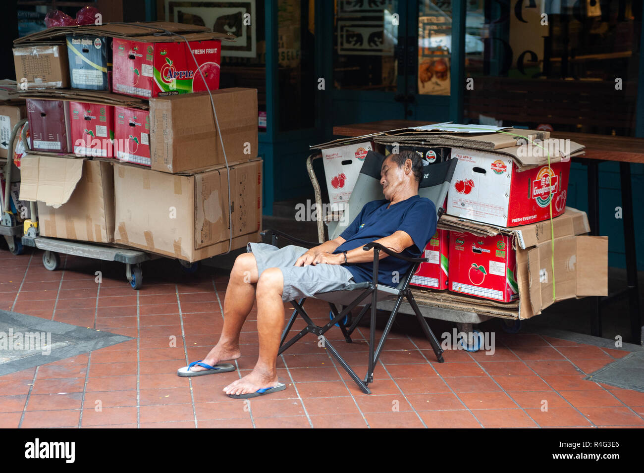 29.07.2018, Singapour, République de Singapour, en Asie - Un homme âgé est assis sur une chaise dans le quartier chinois de Singapour et de district prend une sieste. Banque D'Images