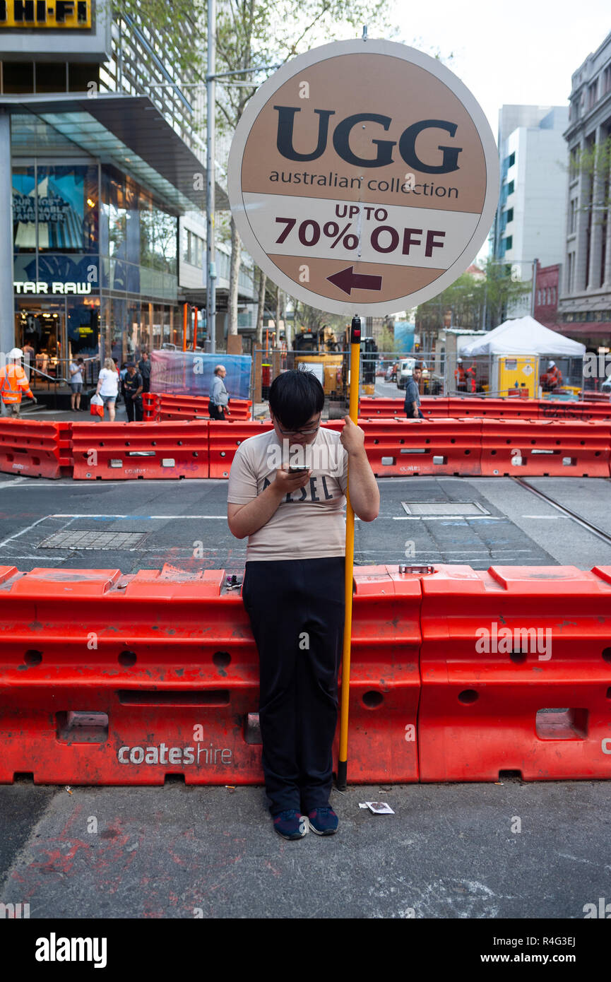 19.09.2018, Sydney, Nouvelle-Galles du Sud, Australie - Un homme asiatique est titulaire d'un panneau publicitaire dans le quartier du centre-ville de la métropole australienne. Banque D'Images