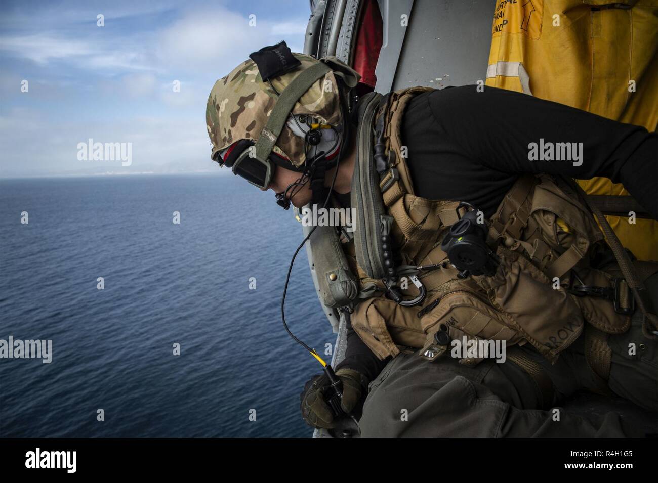 Océan Pacifique (sept. 26, 2018) Aircrewman Naval (hélicoptère) 2e classe Tanner Brown, de Prescott Valley, Arizona), affectés à la "Jokers" de l'Escadron d'hélicoptères de combat de la mer (HSC), 23 maintient la communication avec le pilote d'un MH-60S Sea Hawk au cours d'un ravitaillement vertical avec le navire d'assaut amphibie USS Bonhomme Richard (DG 6). Bonhomme Richard fonctionne dans la 3ème zone d'opérations de la flotte. Banque D'Images