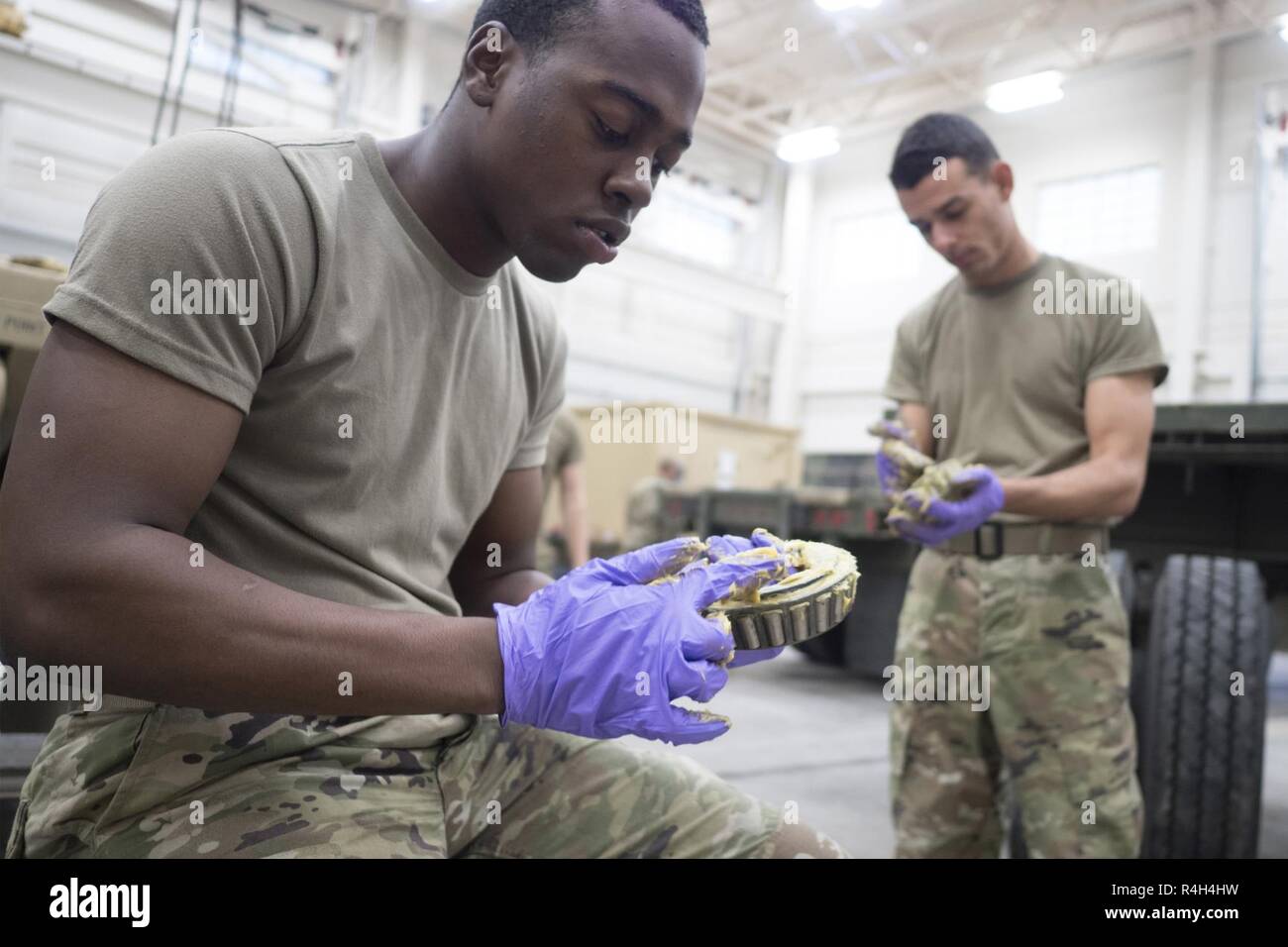 Pvt de l'armée. Va'Quaviyae Hampton, originaire de Chicago, à gauche, et l'Armée Pvt. Cisco Jordan, originaire de Freehold, NJ, tous deux assignés à la 109e compagnie de transport, 17e Bataillon de soutien au maintien en puissance de combat de l'armée américaine, l'Alaska, pack de la graisse dans les roulements de roue alors que d'autres soldats nouvelles remorques processus et effectuer l'entretien sur l'équipement actuel à leur unité motor pool sur Joint Base Elmendorf-Richardson, Alaska, le 28 septembre 2018. La 109TC Des soldats effectuent le transport de véhicule et matériel hebdomadaire de missions et d'USARAK vital actif dans l'Alaska, ainsi que maintenir l'état de préparation au déploiement Banque D'Images