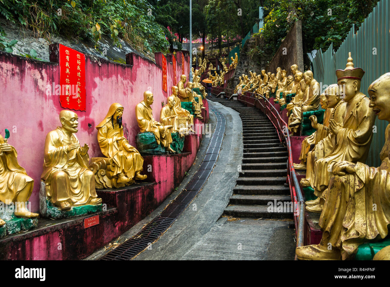 Golden Buddha statues le long de l'escalier menant aux dix mille bouddhas monastère (ZST) Fat Man, Hong Kong, Sha Tin, Nouveaux Territoires Banque D'Images