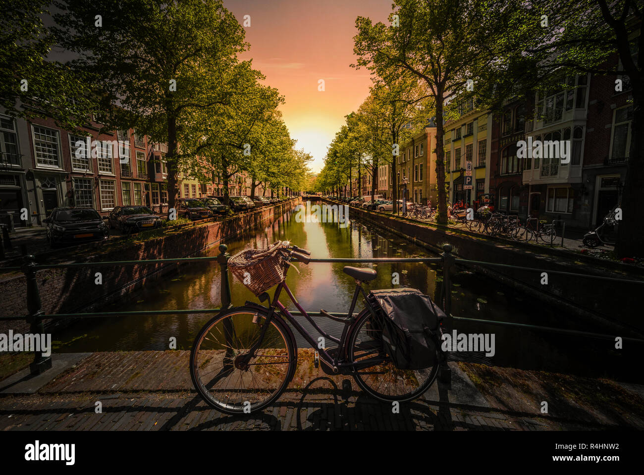 Scène emblématique d'Amsterdam avec le vélo garé sur un pont au-dessus d'un canal d'eau calme, Pays-Bas Banque D'Images