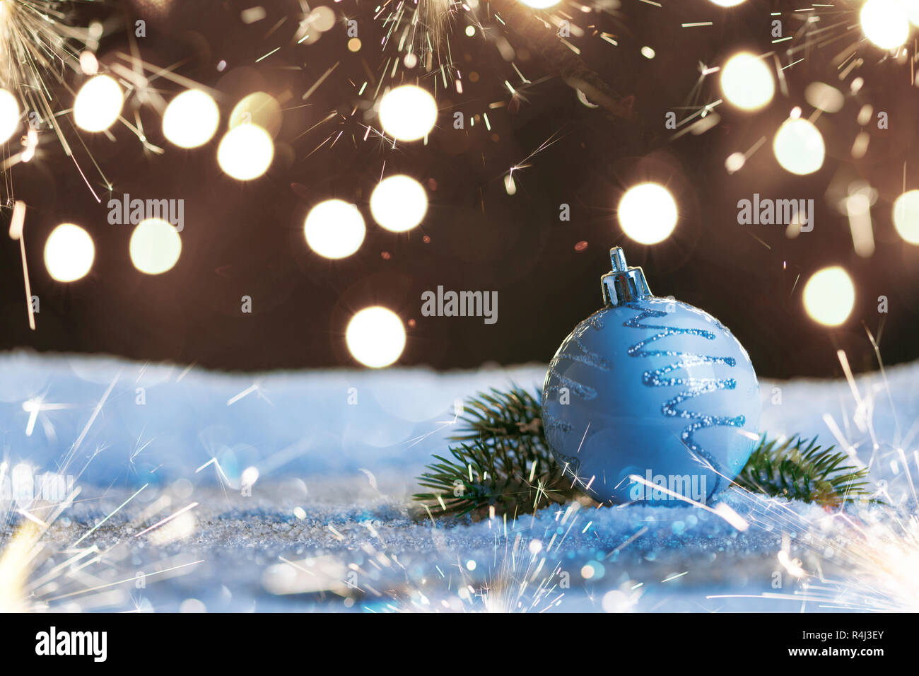 Boule de Noël avec cierges et guirlandes sur la neige Banque D'Images