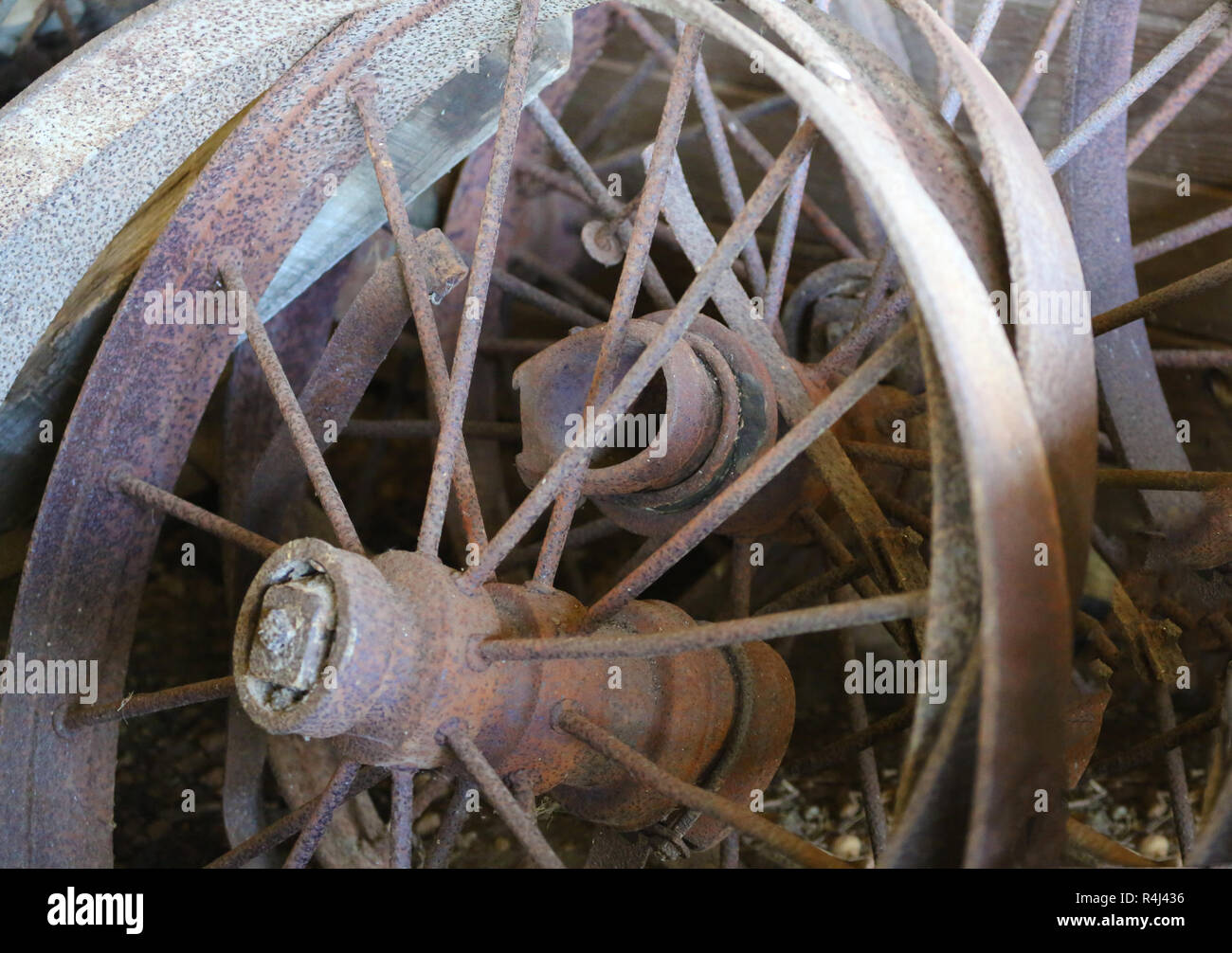 Old rusty metal roues de charrette appuyé contre paroi de l'habitacle Banque D'Images