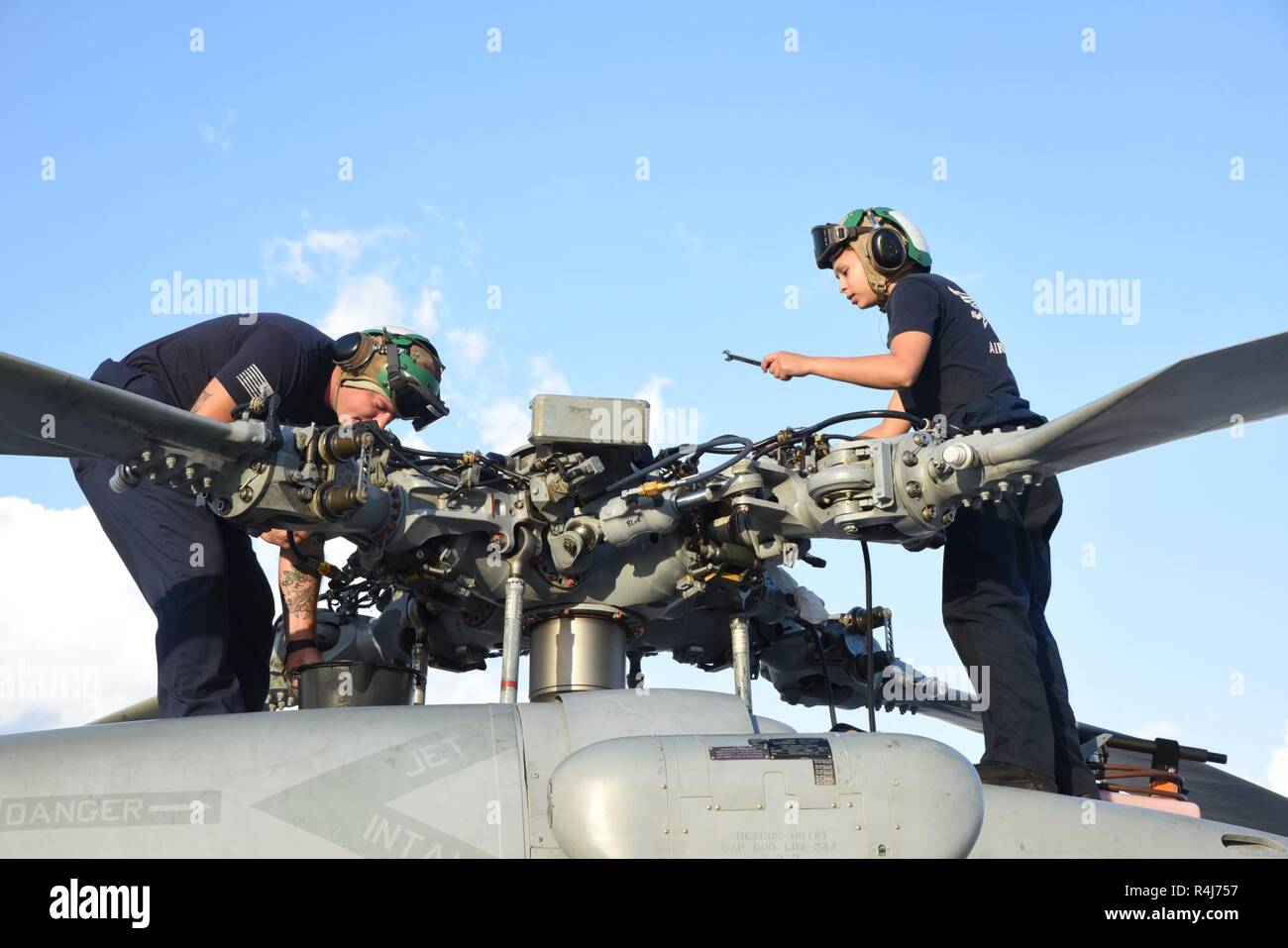 Key West, Floride (nov. 1, 2018) Recherche et sauvetage de l'aviation du département mécanique des structures M1 Christopher Johnson et AMAN Diana Martinez réaliser la maintenance de la tête du rotor principal de l'un des deux de la station de l'air MH-60S Seahawks.NAS Key West est un établissement de pointe pour les combats air-air des avions de tous les services militaires et fournit un soutien aux pierside navires de guerre américains et étrangers. Banque D'Images