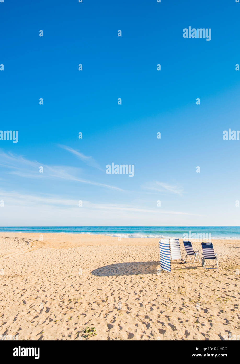 Chaises bleu et blanc et à l'abri du vent plage déserte, Praia Grande, armacao de pera, Algarve, PORTUGAL Banque D'Images