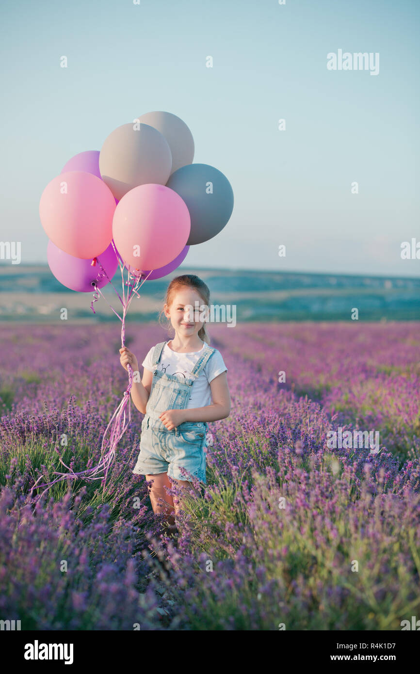 Une jeune fille dans un champ de lavande avec des ballons Banque D'Images