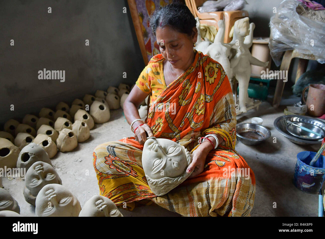 Un artiste indien vu préparation de l'argile idol visages de déesses Durga, l'avant de la Durga Puja festival à l'intérieur d'un studio à Agartala. Durga Puja, le festival hindou annuel qui implique l'adoration de la déesse Durga, qui symbolise la puissance et le triomphe du bien sur le mal dans la mythologie hindoue, culmine dans l'immersion du corps des idoles dans l'eau. Banque D'Images