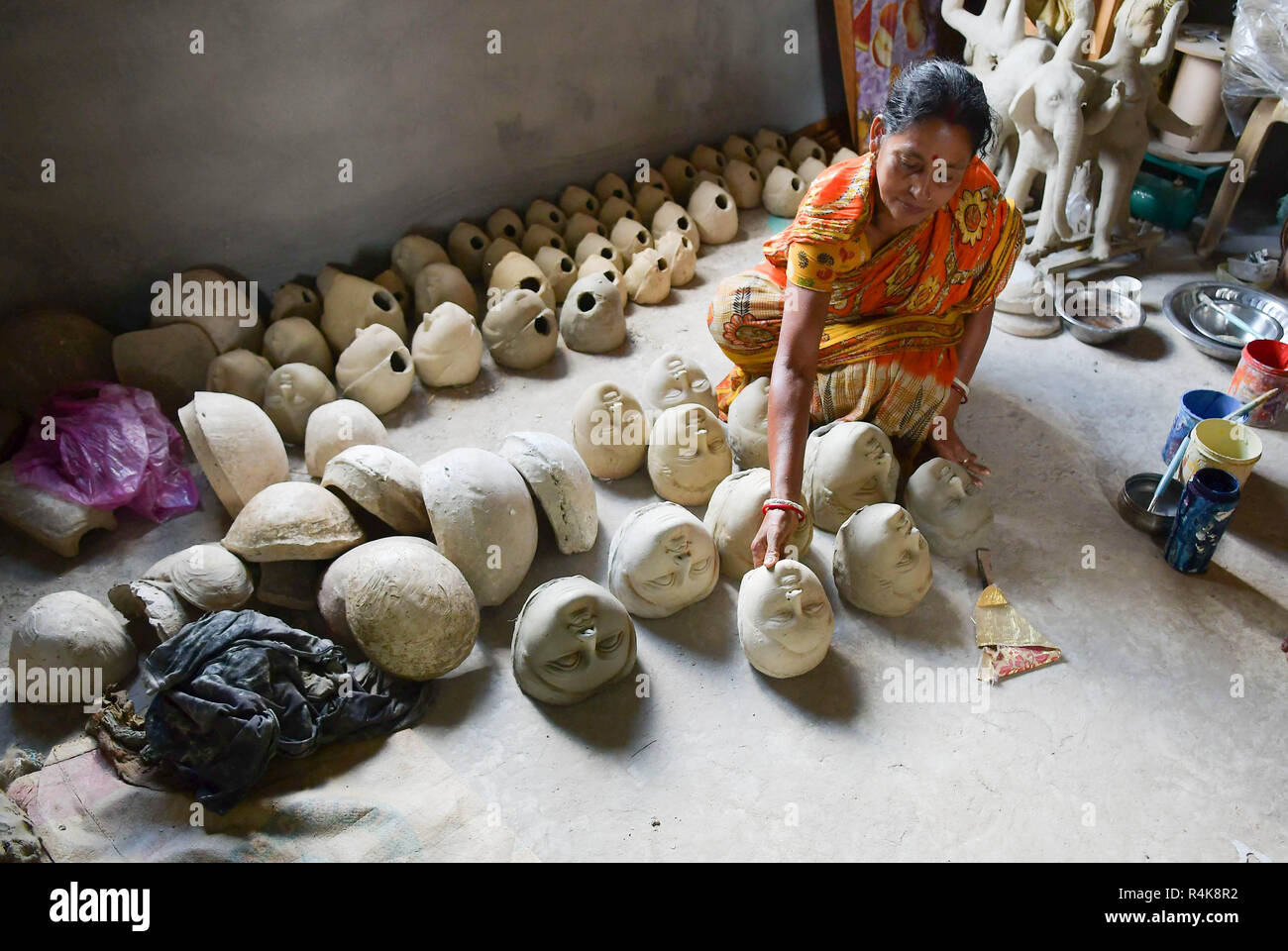 Un artiste indien vu préparation de l'argile fait face à idol de Durga, déesses de l'avant de la Durga Puja festival à l'intérieur d'un studio à Agartala. Durga Puja, le festival hindou annuel qui implique l'adoration de la déesse Durga, qui symbolise la puissance et le triomphe du bien sur le mal dans la mythologie hindoue, culmine dans l'immersion du corps des idoles dans l'eau. Banque D'Images
