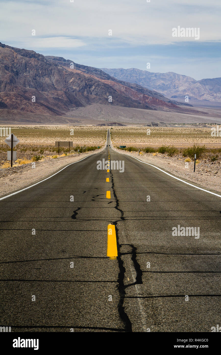 Long, route droite qui traverse paysage aride de la Death Valley, Californie, USA Banque D'Images
