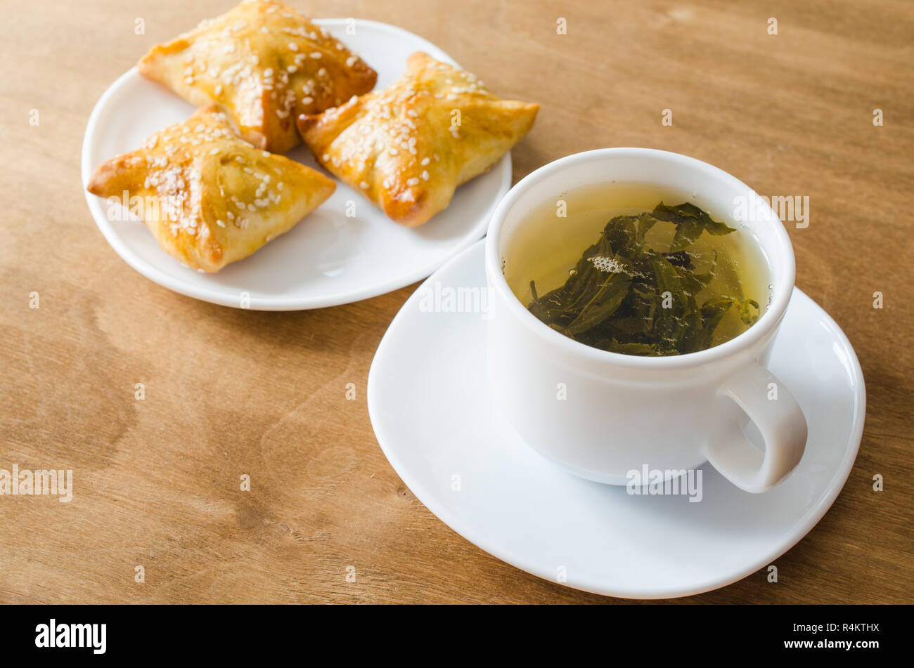 Du thé vert et de pâtés sur table en bois rustique Banque D'Images