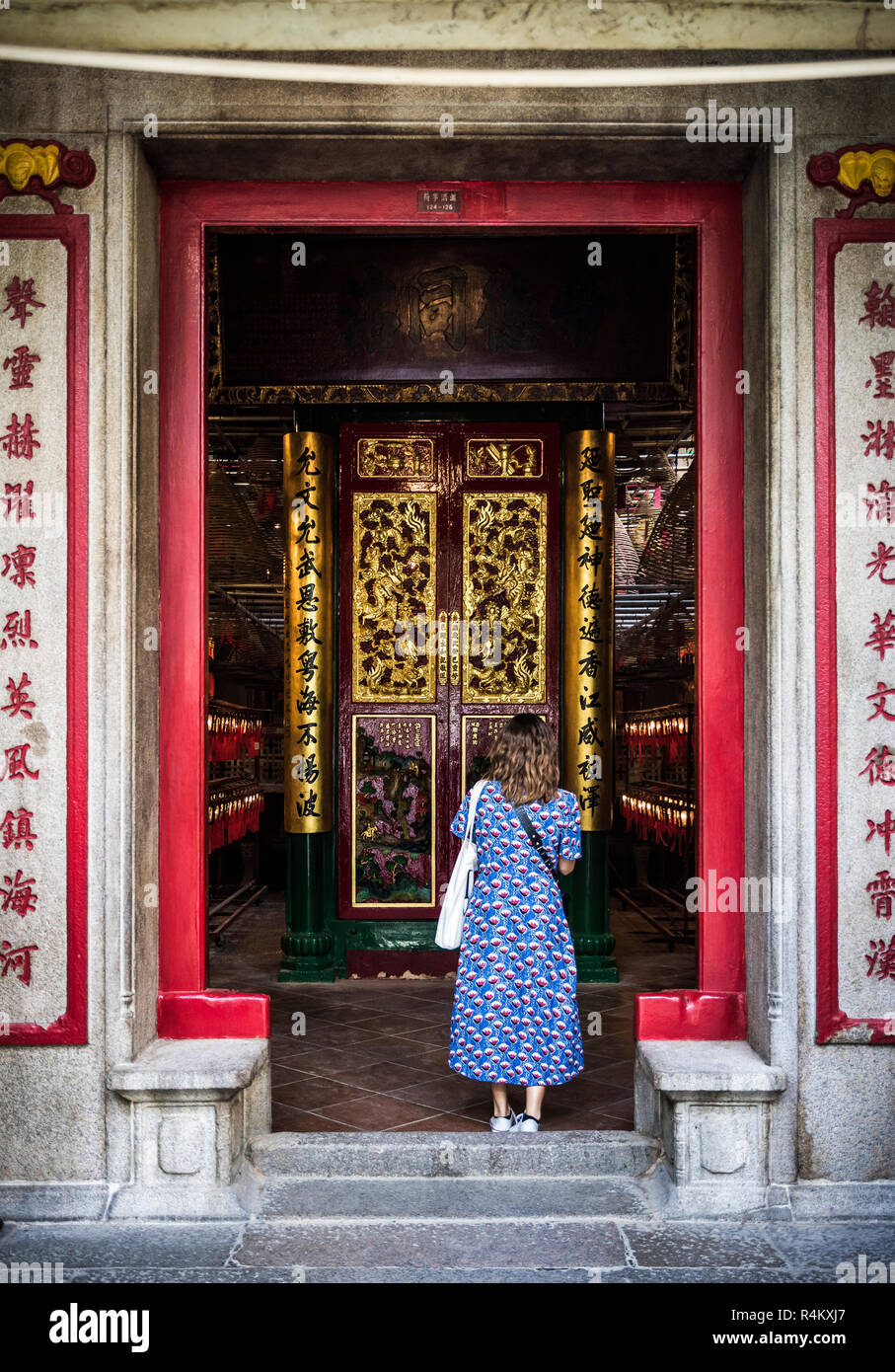 Une femme se tient à l'entrée du Temple Man Mo, Sheung Wan, Hong Kong Banque D'Images