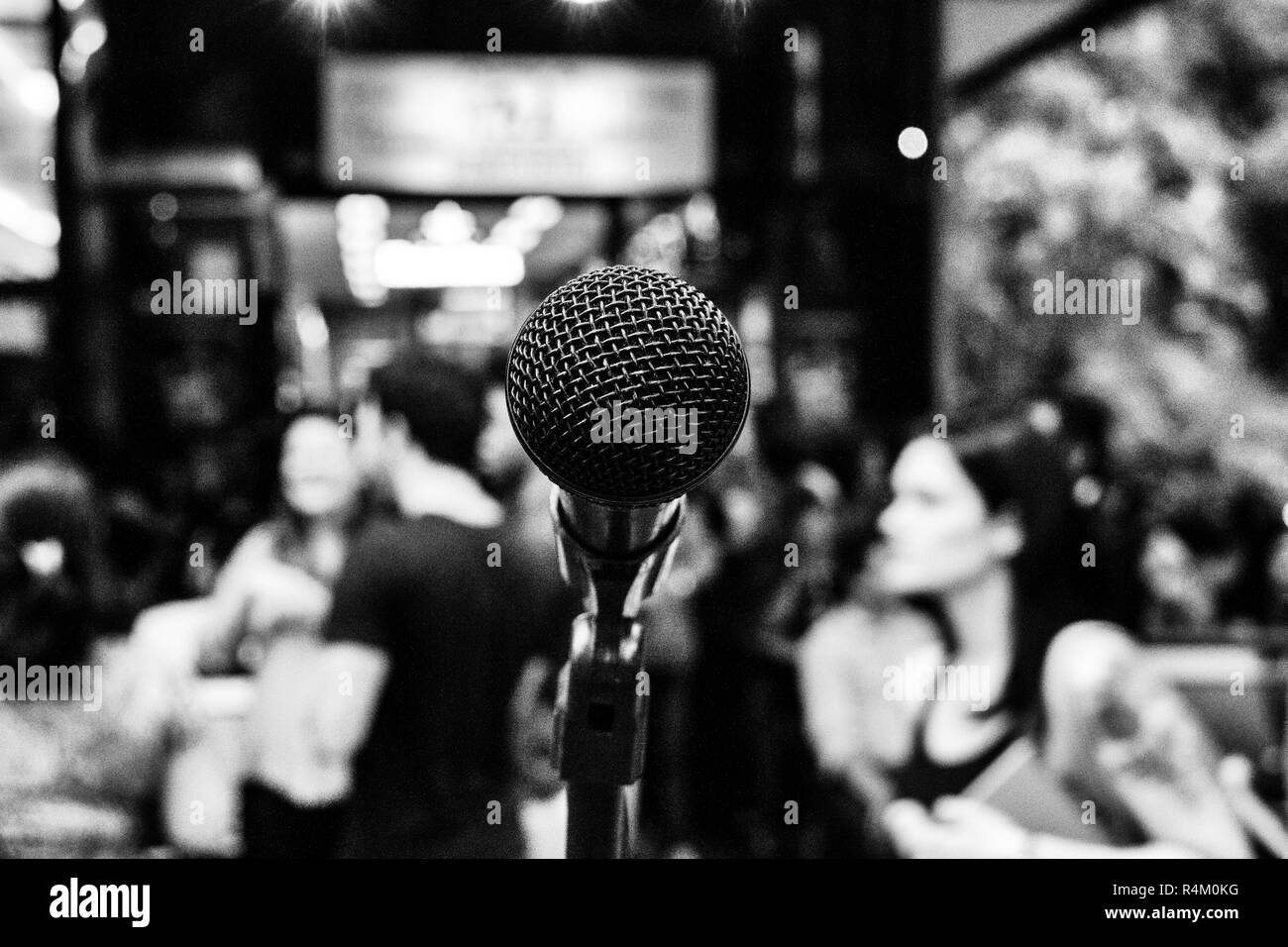 Fond noir et blanc d'un microphone dans la rue en face d'un bar plein de gens sur une bonne heure après le travail sur un après-midi d'été je Banque D'Images