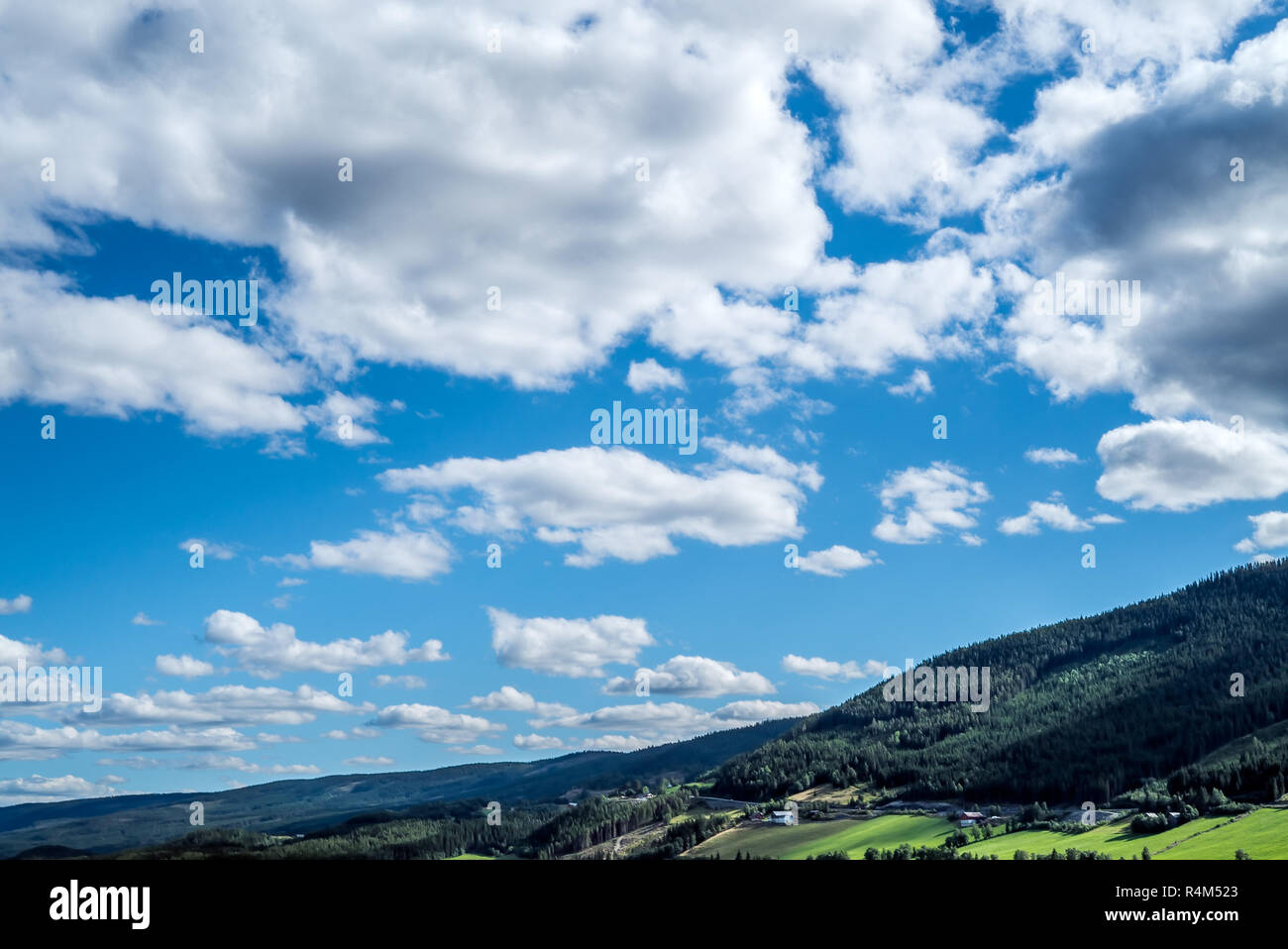 Une vue panoramique et spectaculaire avec de nombreux nuages Cloudscape sur un ciel bleu au-dessus des montagnes, collines rural idyllique avec des terres agricoles agricoles Banque D'Images