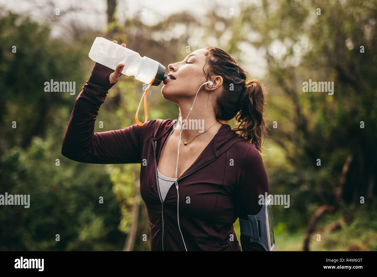 Coureuse l'eau potable après une période de travail à l'extérieur. Woman getting a hydraté après exécution de l'entraînement. Banque D'Images