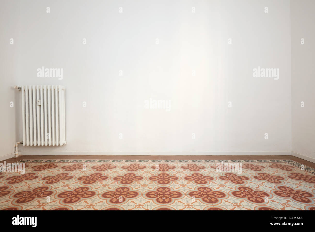 Salle vide avec des murs blancs, carrelage avec décoration florale Banque D'Images