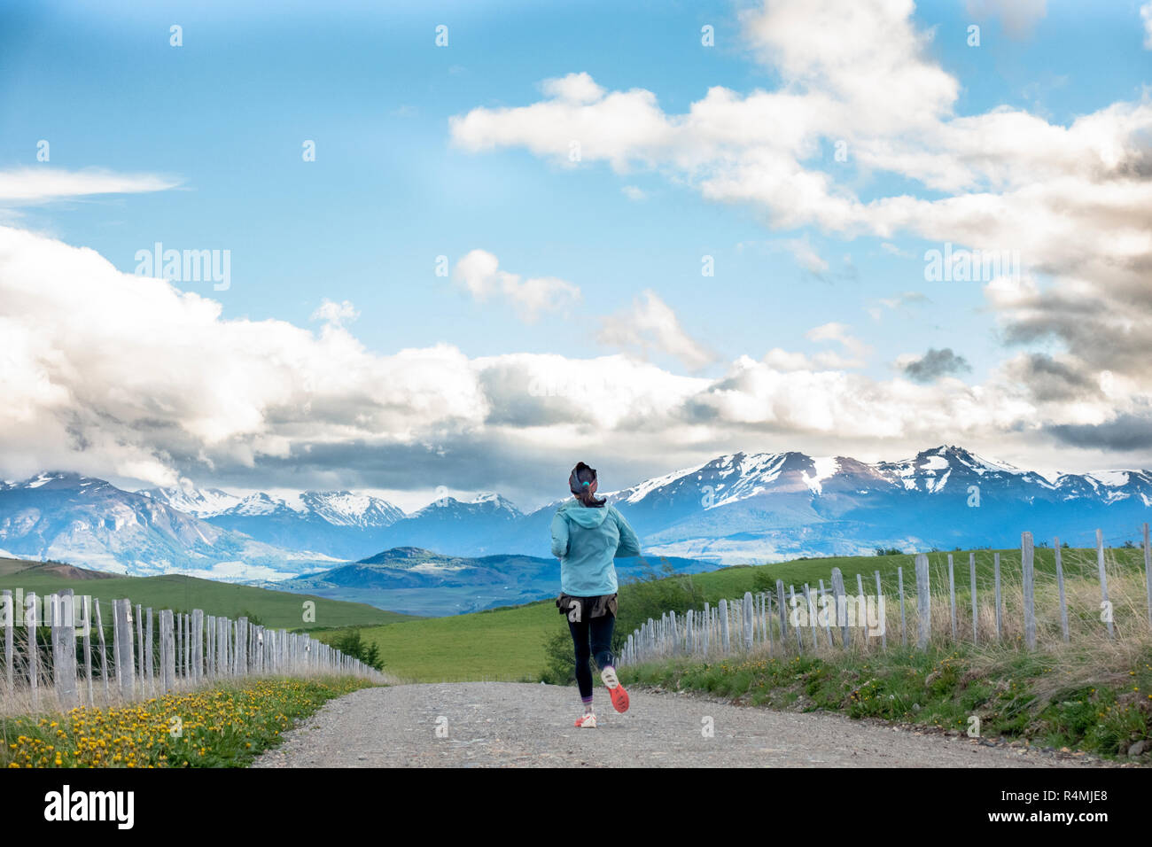 Femme en marche sur un chemin de terre avec de belles montagnes en arrière-plan, près de Santiago, au Chili dans la région d'Aysen près de Patagonie. Banque D'Images