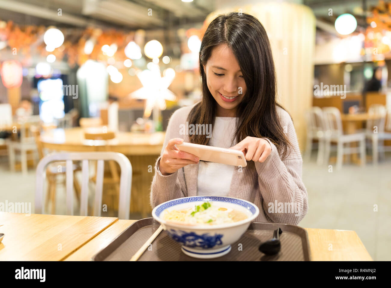 Woman taking photo dans son restaurant de ramen Banque D'Images
