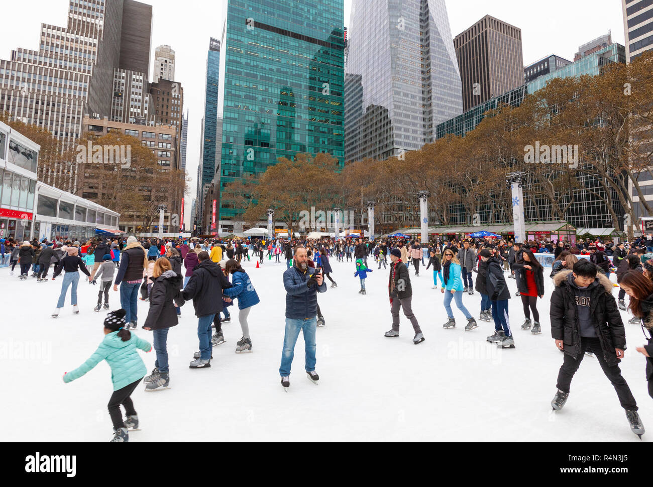 Les familles, les gens, les amis du patinage sur glace au Village d'hiver au Bryant Park, à Manhattan, New York City. Banque D'Images