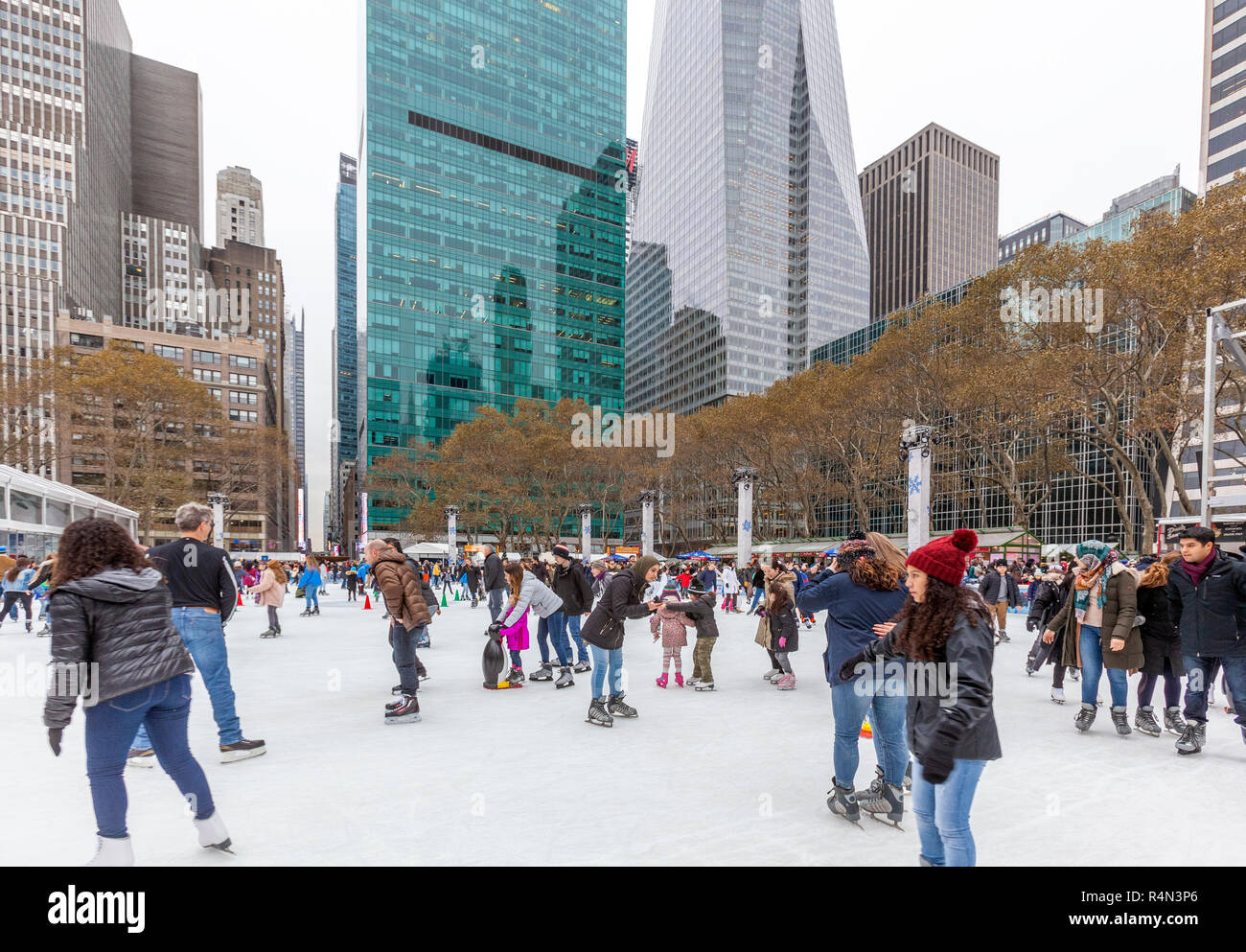 Les familles, les gens, les amis du patinage sur glace au Village d'hiver au Bryant Park, à Manhattan, New York City. Banque D'Images