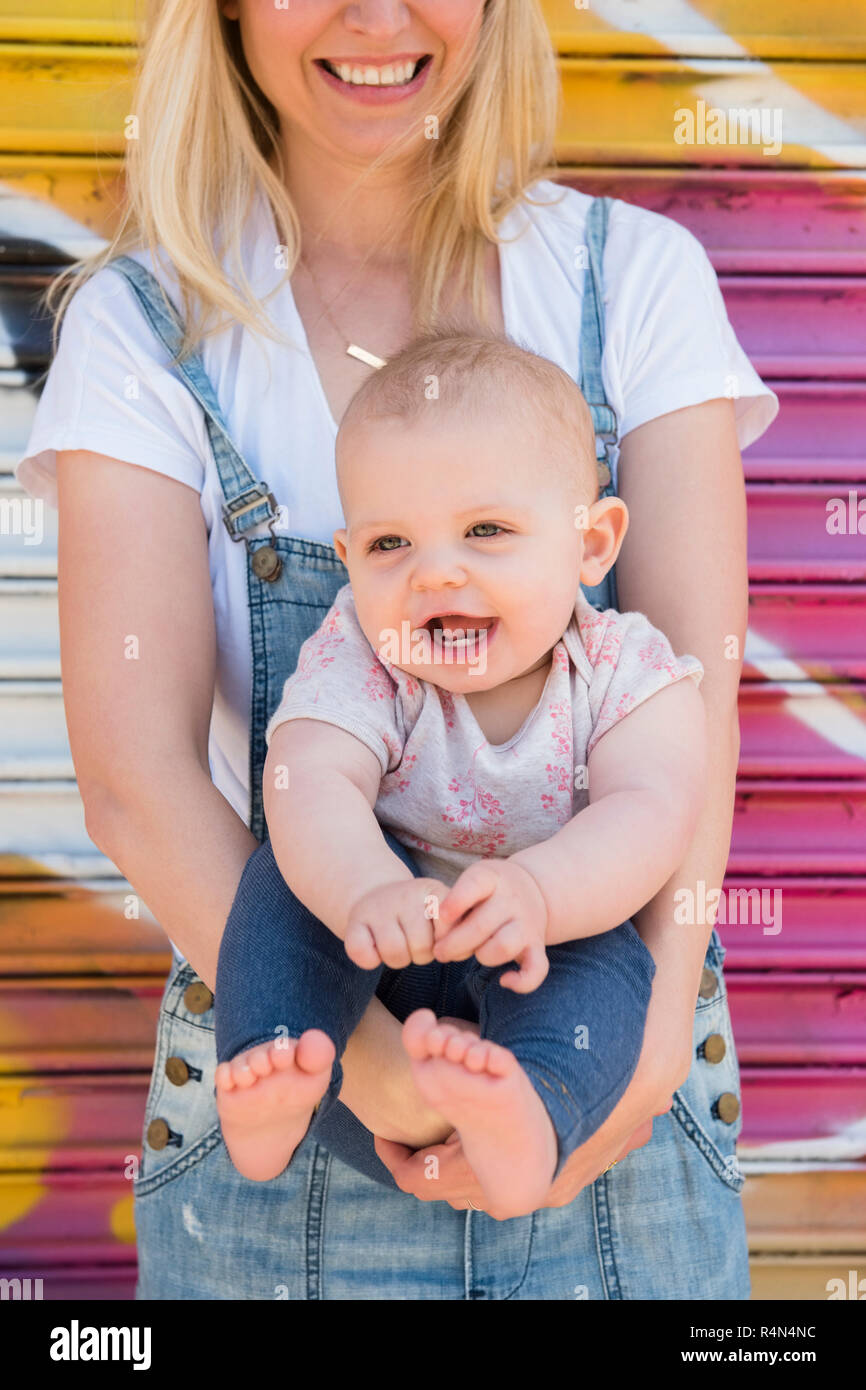 Smiling baby girl étant détenu par sa mère Banque D'Images Smiling baby girl étant détenu par sa mère Banque D'Images