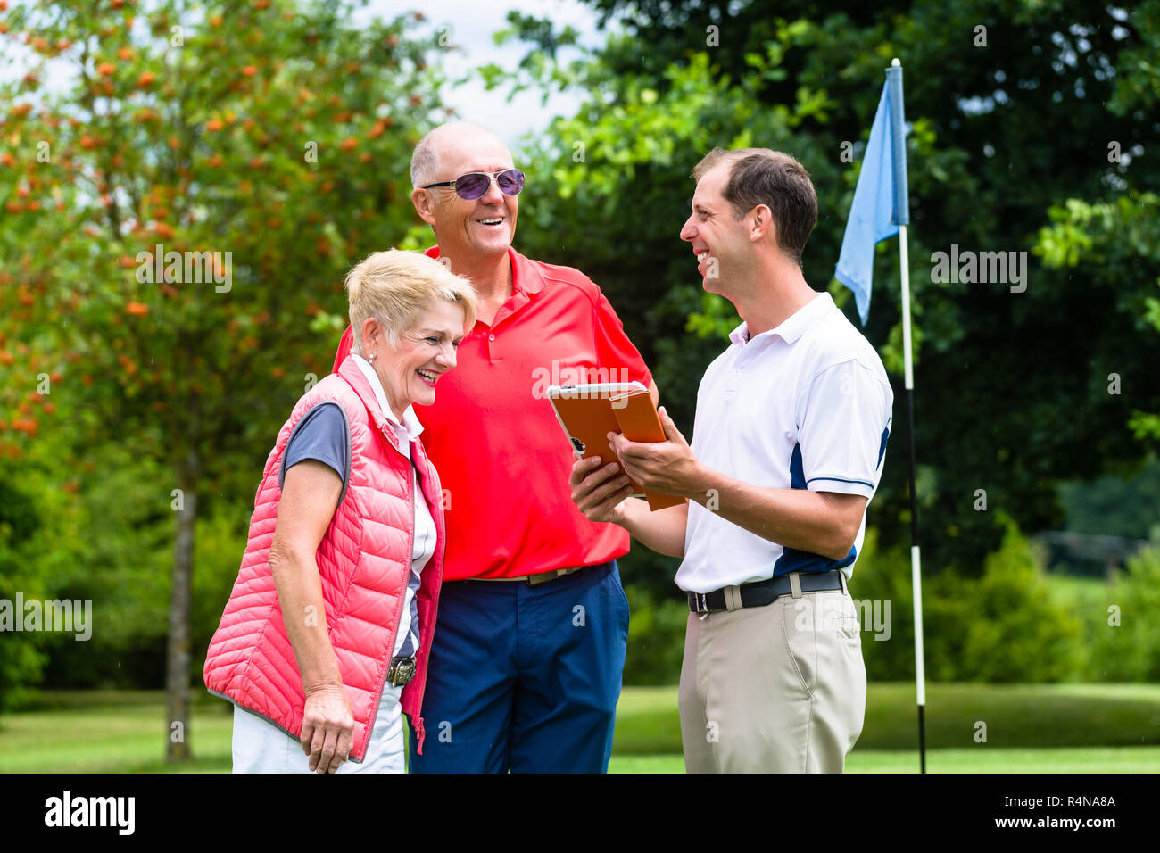 Golf pro avec femme et homme senior à l'analyse des résultats Banque D'Images