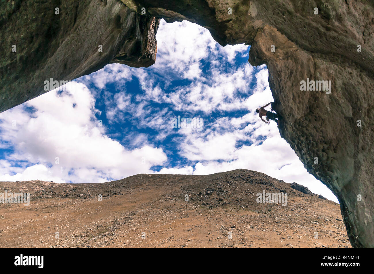 Vue éloignée de l'homme aventureux une escalade falaise en surplomb à Hatun Machay également connu sous le nom de Bosque de Piedra, Recuay Province, Pérou Banque D'Images