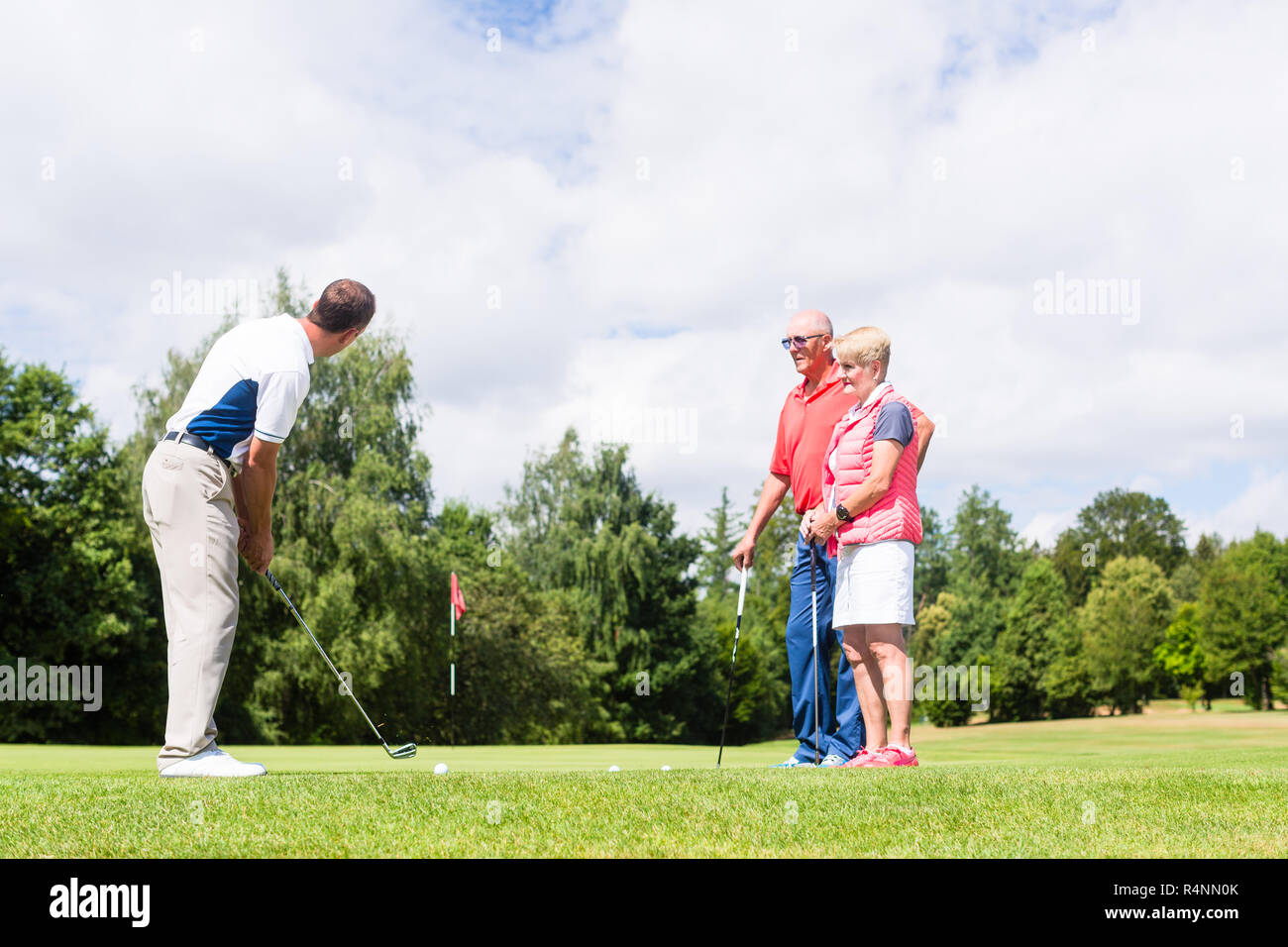 La pratique de ce sport golf pro avec des cadres supérieurs et l'homme femme Banque D'Images