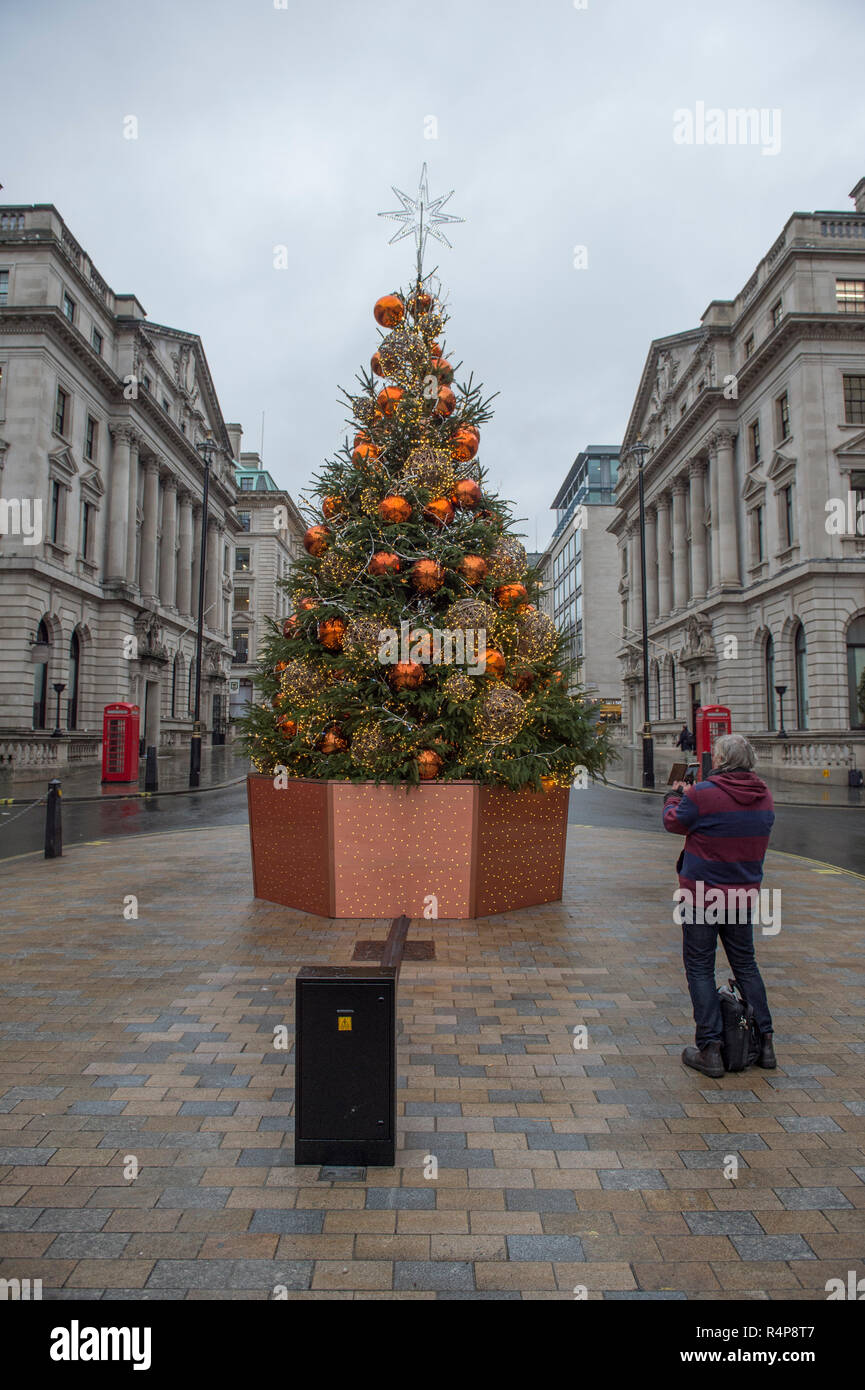 Regent Street Saint James's, London, UK. 28 novembre, 2018. La saison n'a pas encore apparaître dans Londres, un arbre de Noël dans l'extrémité ouest se trouve dans la pluie sur un doux et gris journée de novembre et est photographié par un passant. Credit : Malcolm Park/Alamy Live News. Banque D'Images