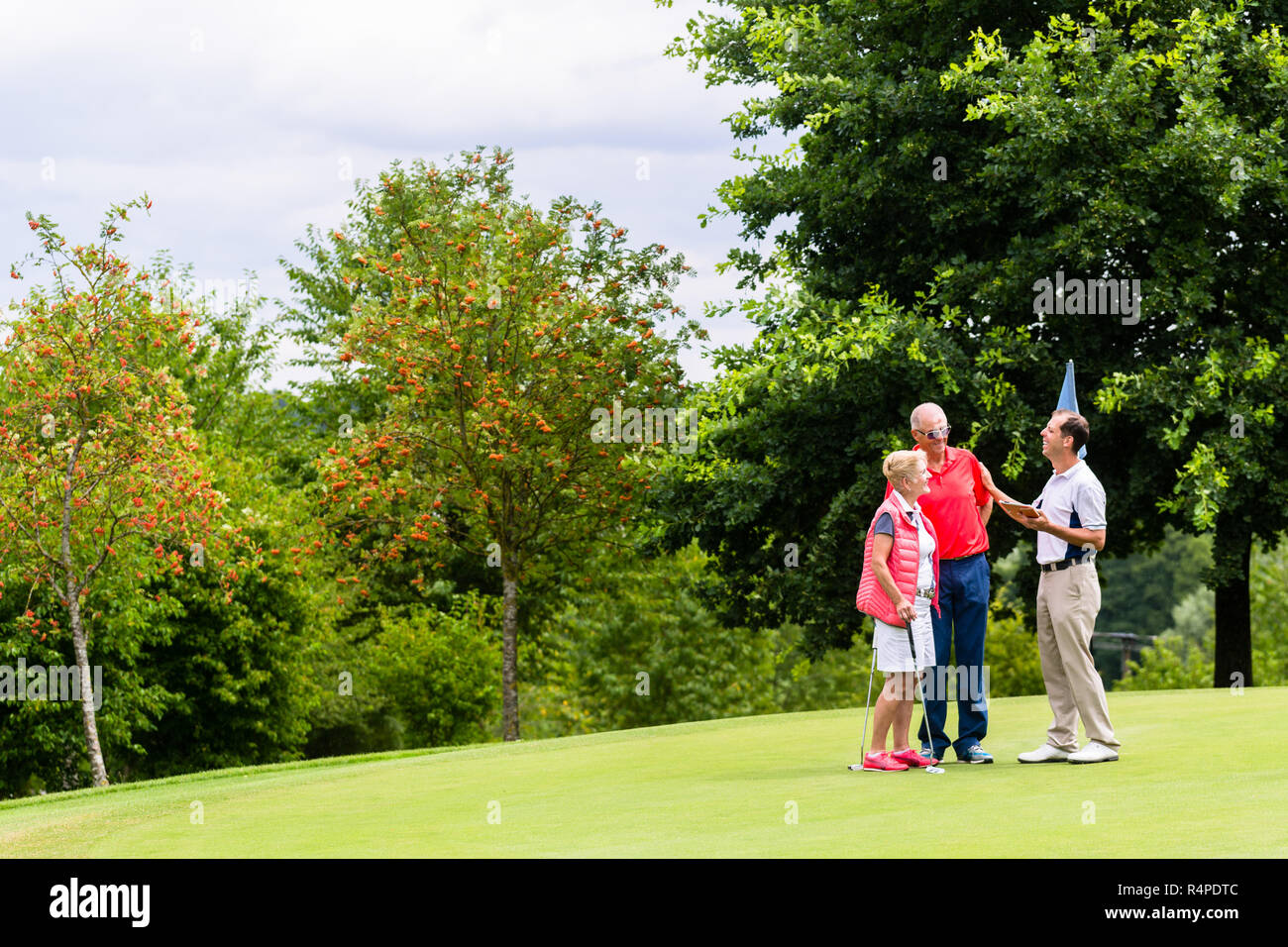 Golf pro avec femme et homme senior à l'analyse des résultats Banque D'Images