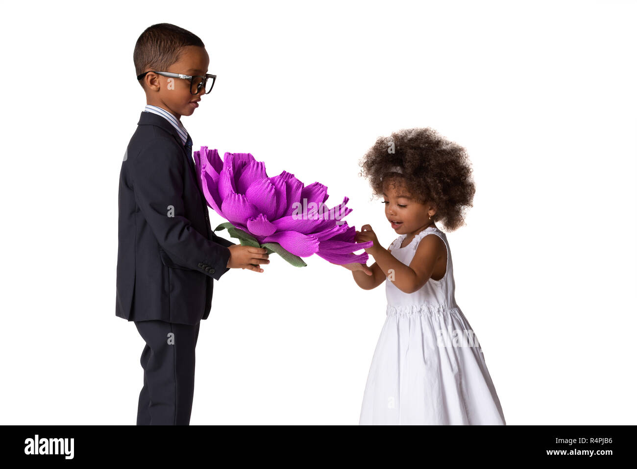 Beau garçon donne une jolie fille grande fleur origami.Les enfants adorent.isolé sur fond blanc Banque D'Images