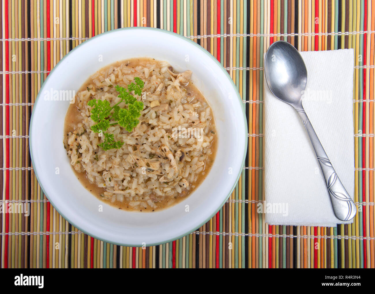 Bol de riz Turquie maison soupe dans un bol blanc avec cuillère et serviette sur une paille de couleur automne napperon. L'utilisation parfaite pour les restes de dinde Banque D'Images