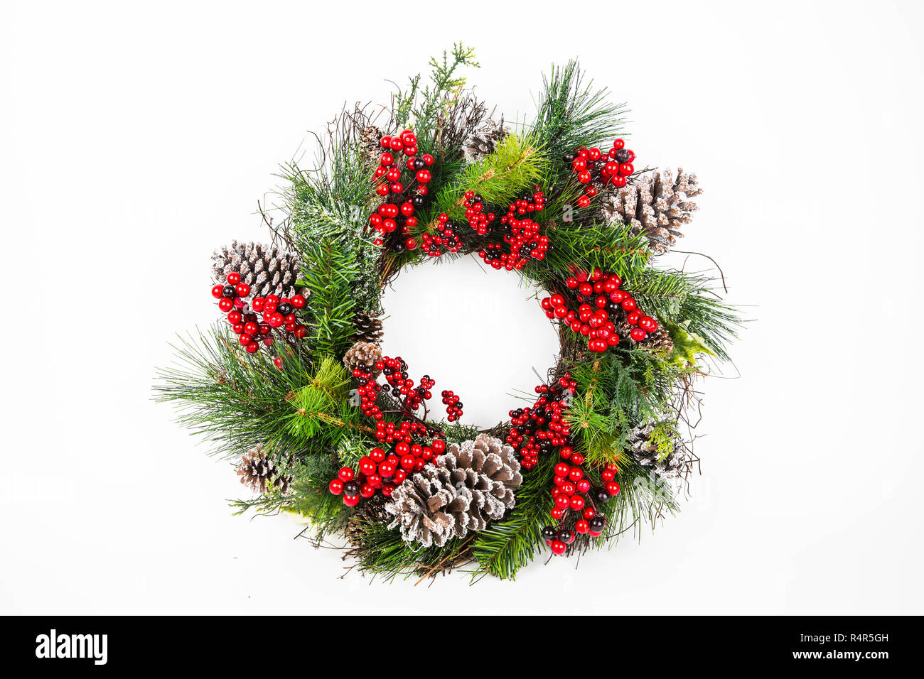 Couronne de noël faites de branches de Pins à la recherche naturaliste décorées avec des baies d'hiver et des pommes de pin Banque D'Images