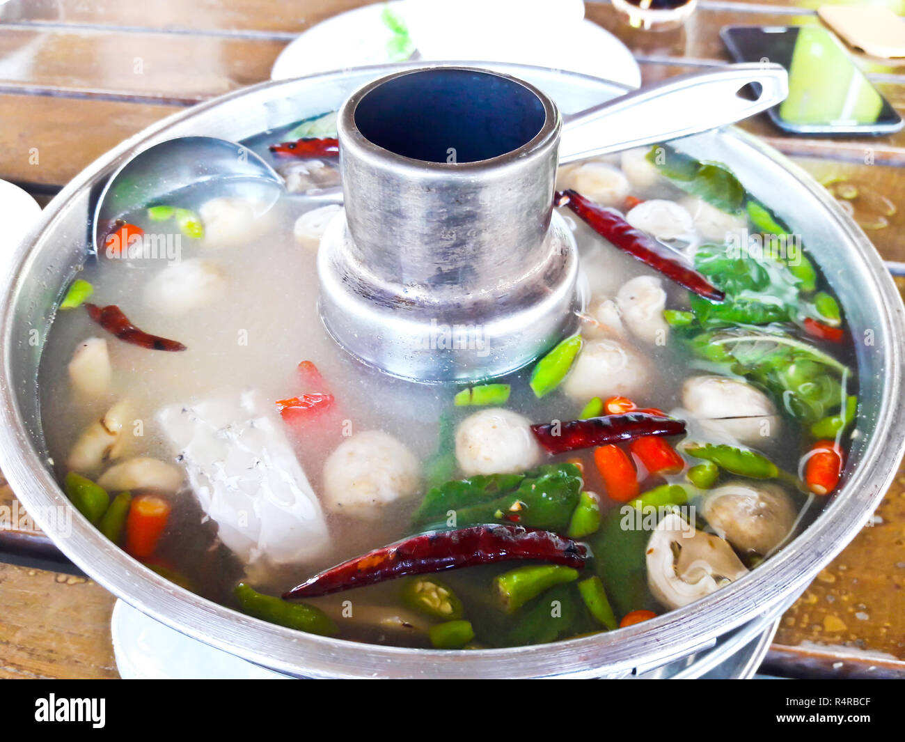 Servir la soupe de poisson épicée de style thaïlandais dans un pot chaud Banque D'Images