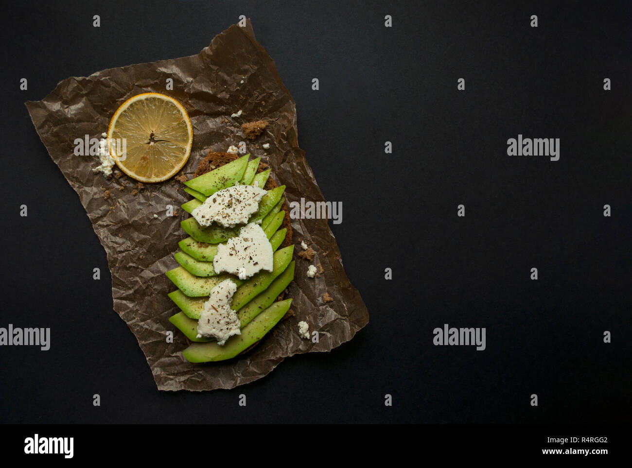 Délicieux toasts frais d'avocat avec le fromage blanc. Le petit-déjeuner végétarien sain avec farine de seigle sandwich. Banque D'Images