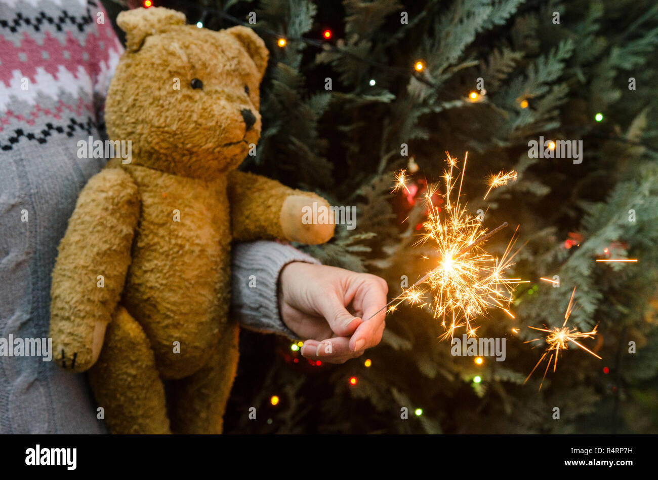 Scène de Noël - femme tenant l'ours en peluche et sparkler avant Noël tree Banque D'Images