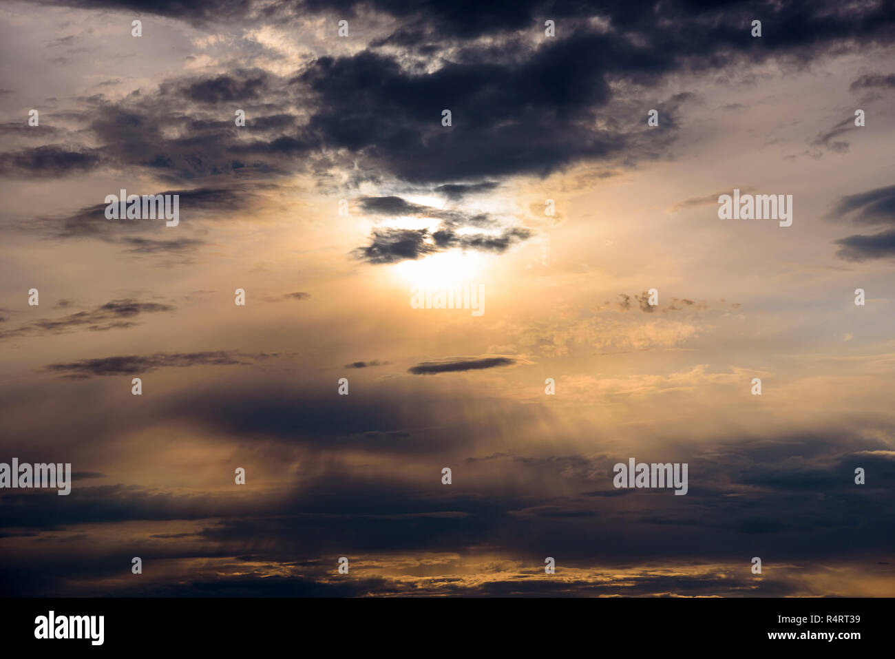 Rayons de roues, par les sombres nuages au coucher du soleil Banque D'Images