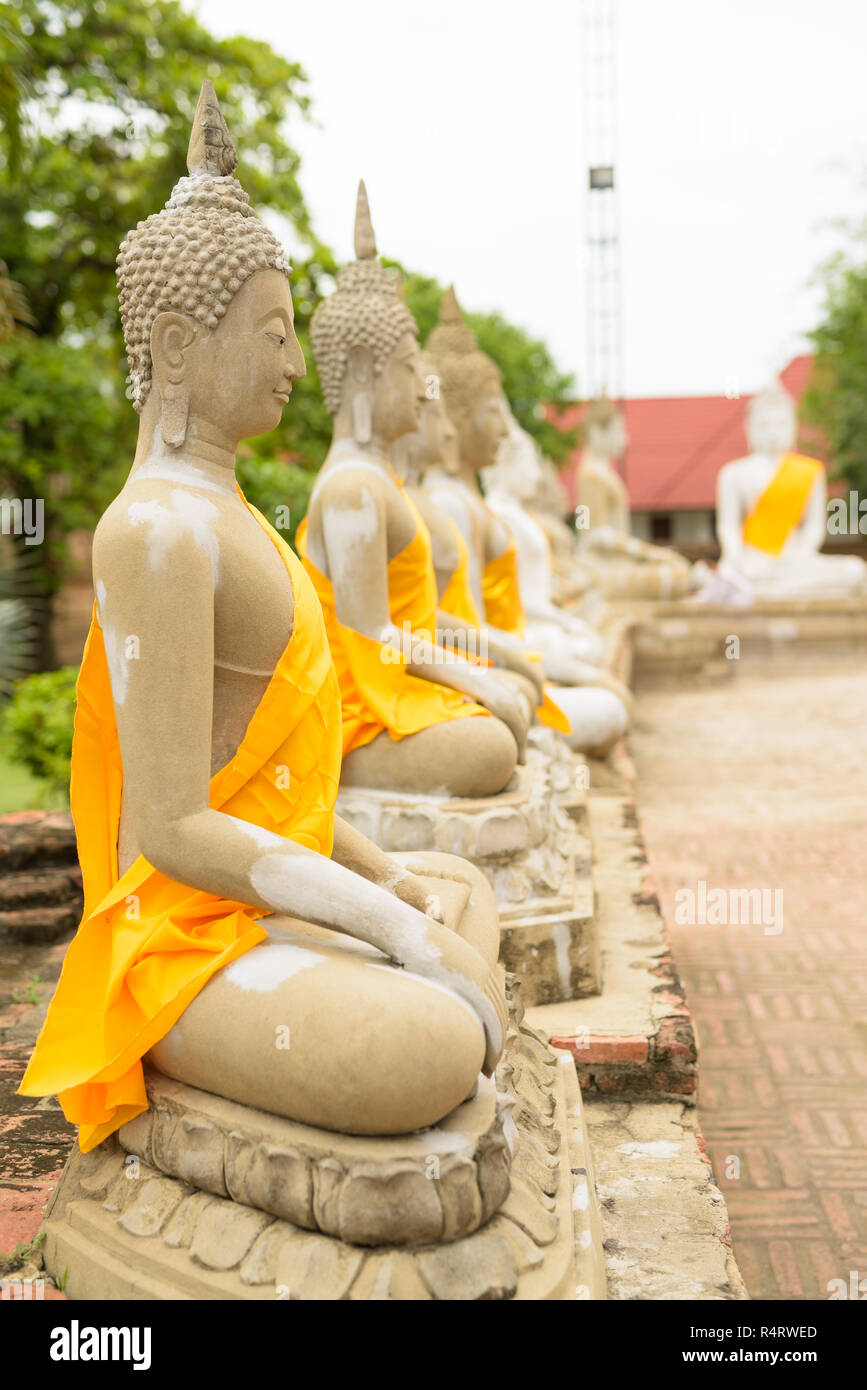 Sculpture de Bouddha en rangs avec robe jaune enroulé autour de chaque Banque D'Images
