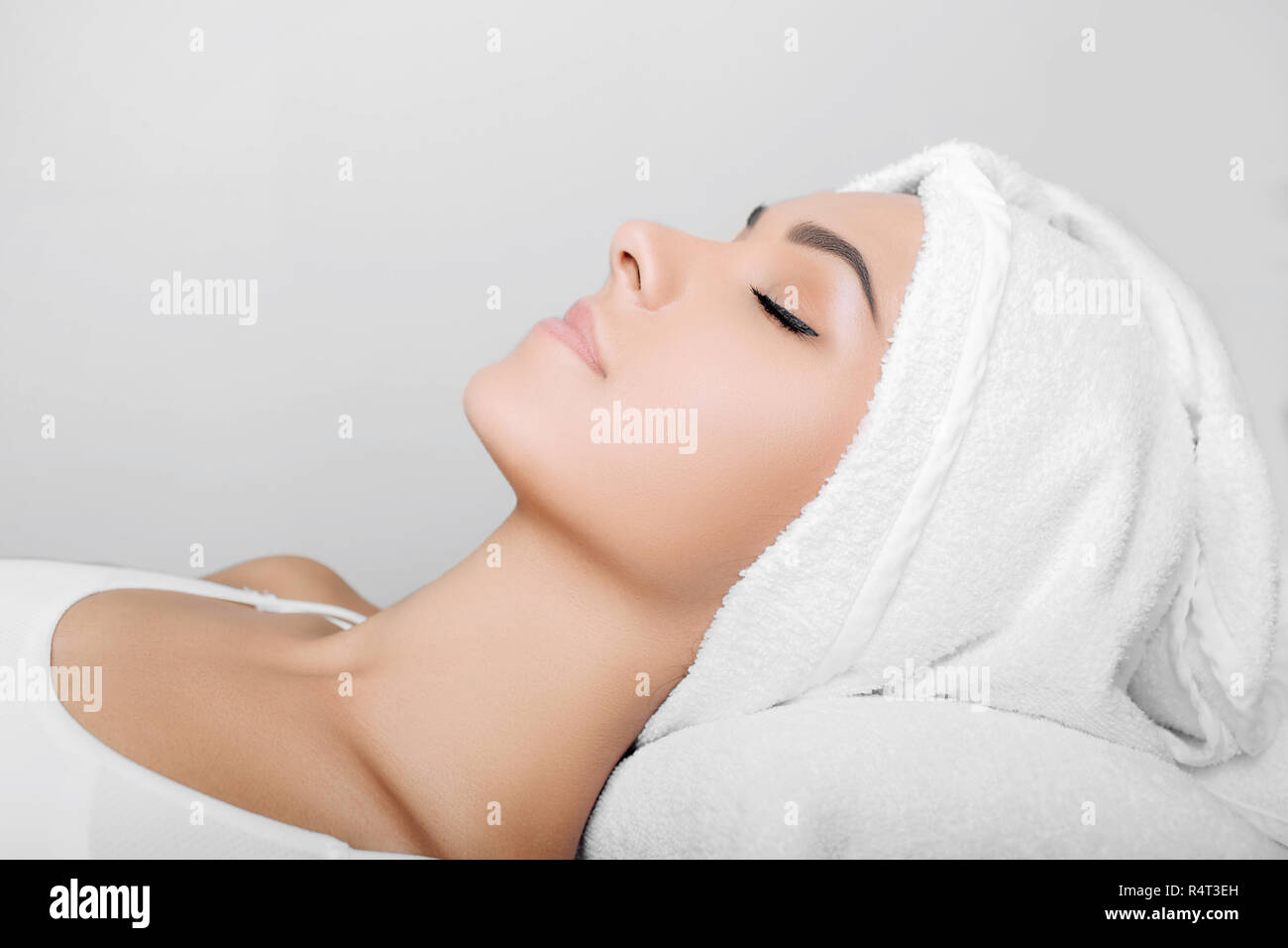 Claire douce femme avec une serviette sur la tête, un spa relaxant Banque D'Images