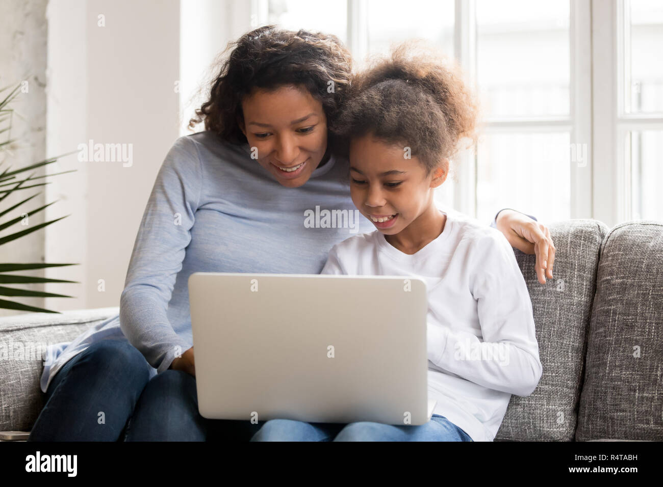 Happy African American mother and daughter using laptop Banque D'Images