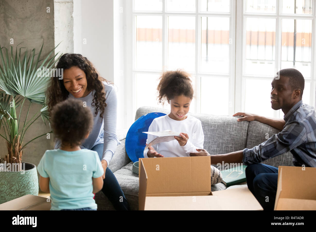 Happy African American family unpacking boxes, tout déménagement Banque D'Images