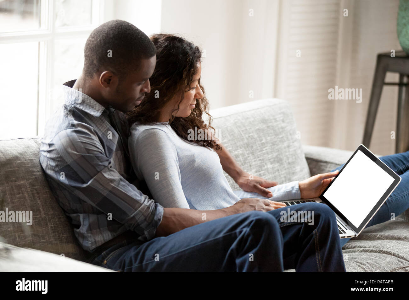 Embrassant African American couple using laptop together Banque D'Images