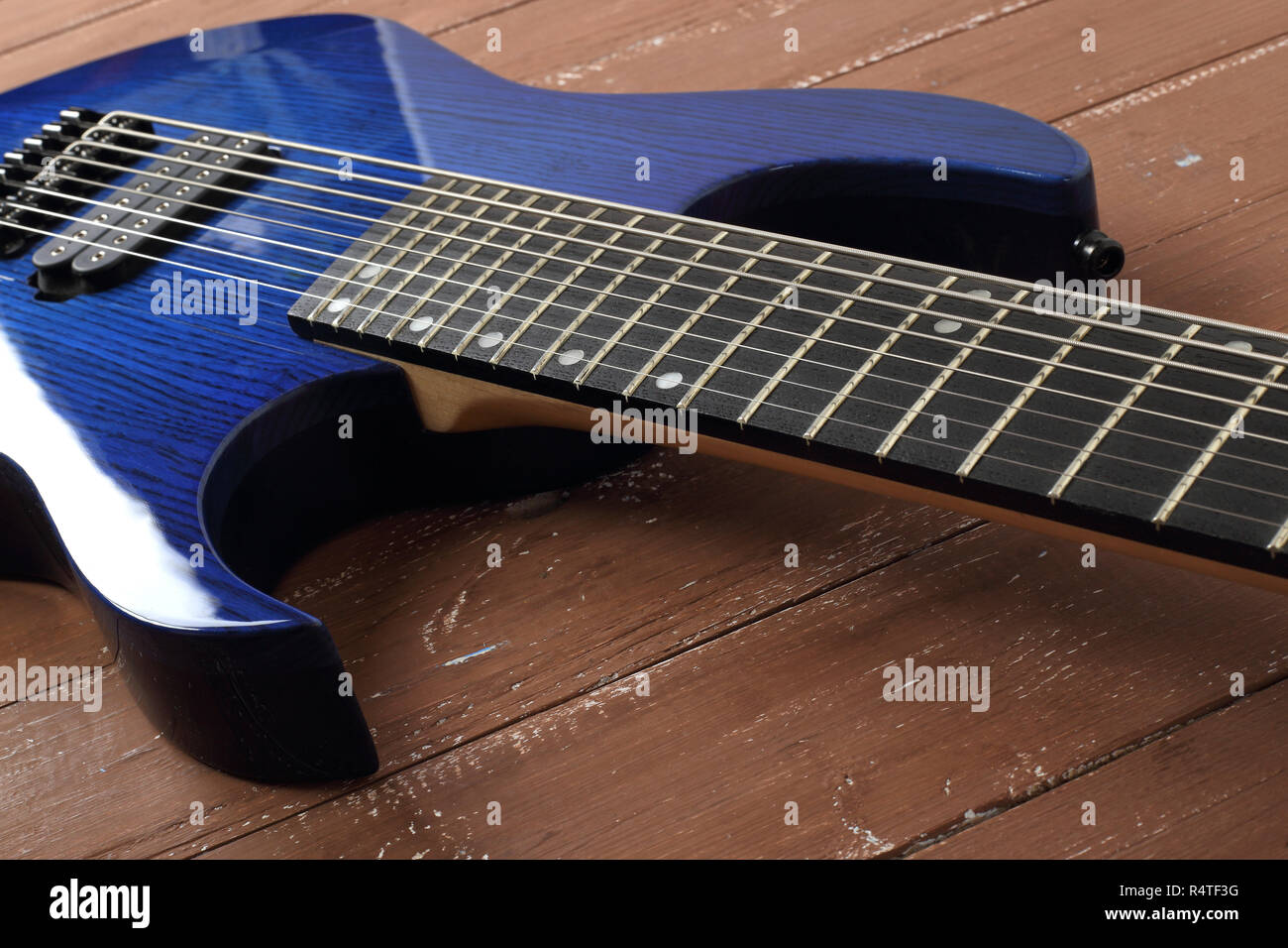 Instrument de musique - fragment 8-string blue guitare électrique solid-body sur un fond de bois Banque D'Images