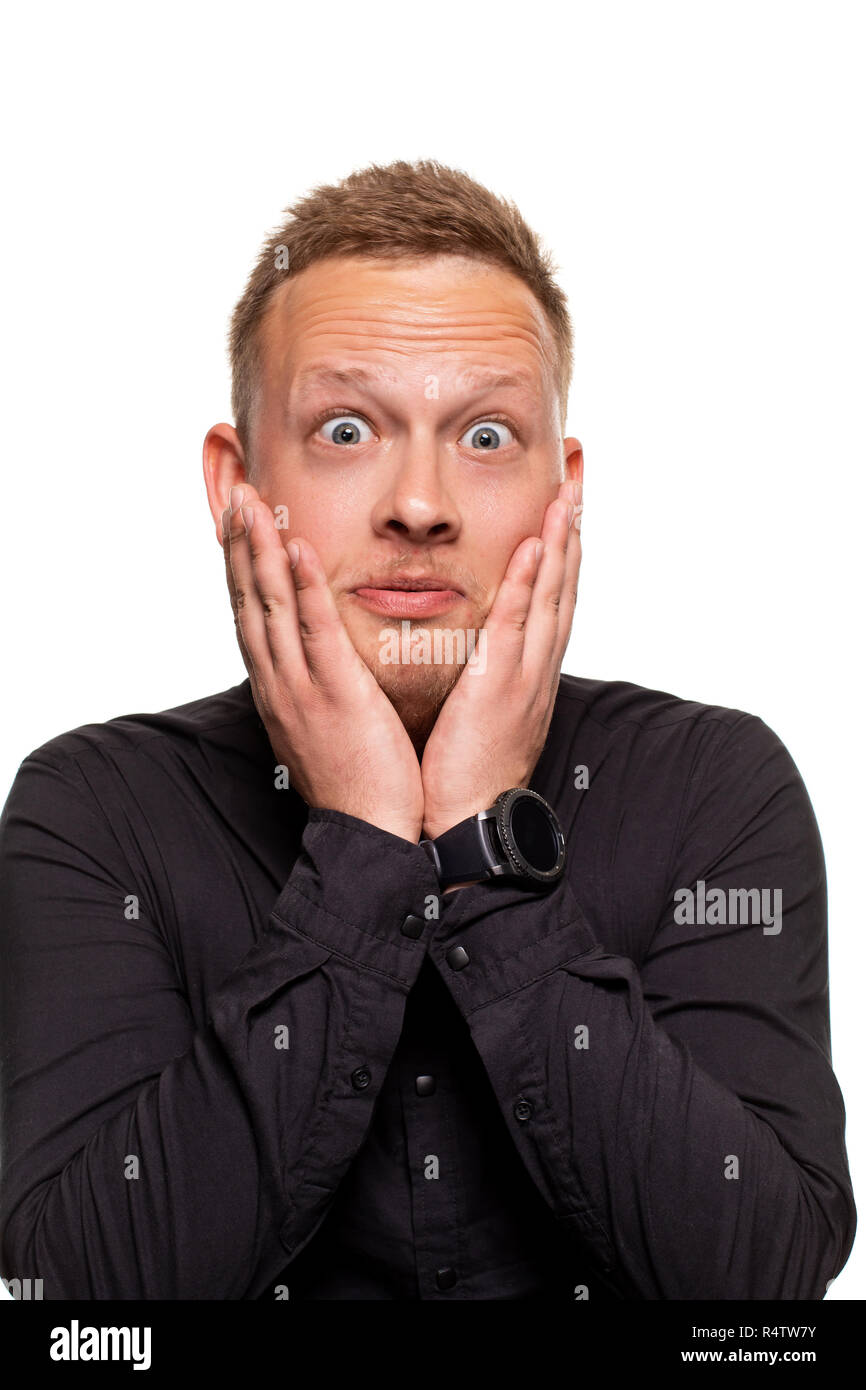 Portrait d'un homme en chemise noire holding palms près de la joue. Les expressions du visage et le concept de réaction Banque D'Images