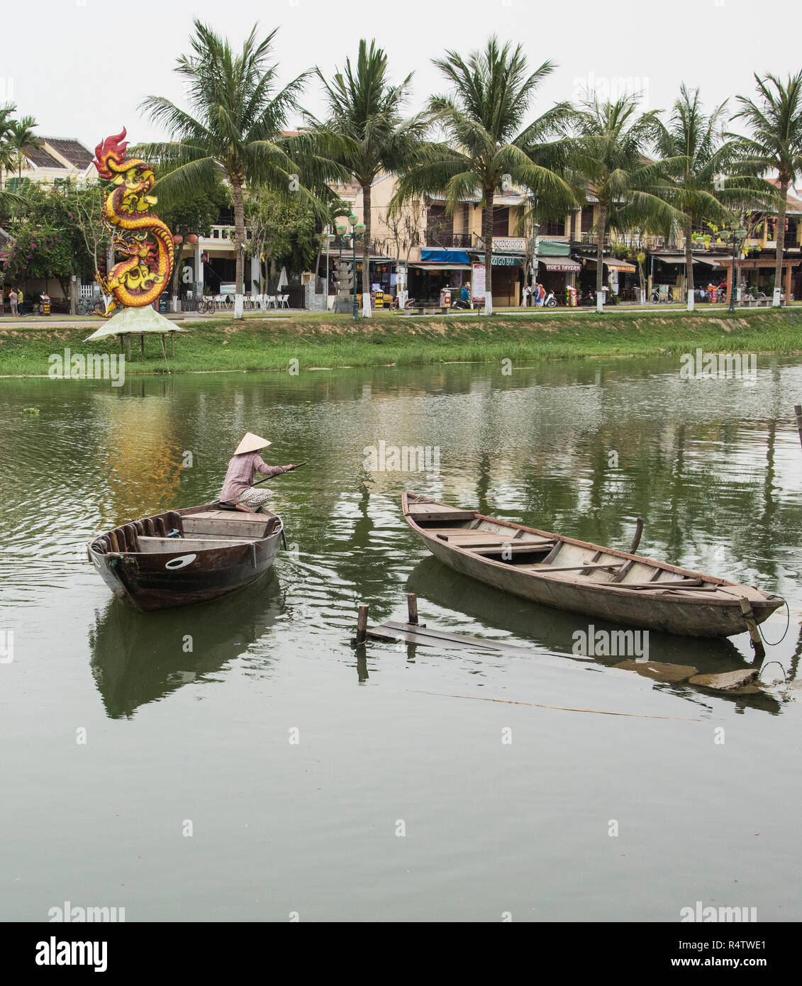 Dame vietnamiens traditionnels traversant la rivière bon dans un bateau dans la vieille ville de Hoi An Vietnam site du patrimoine mondial de l'unesco. Banque D'Images