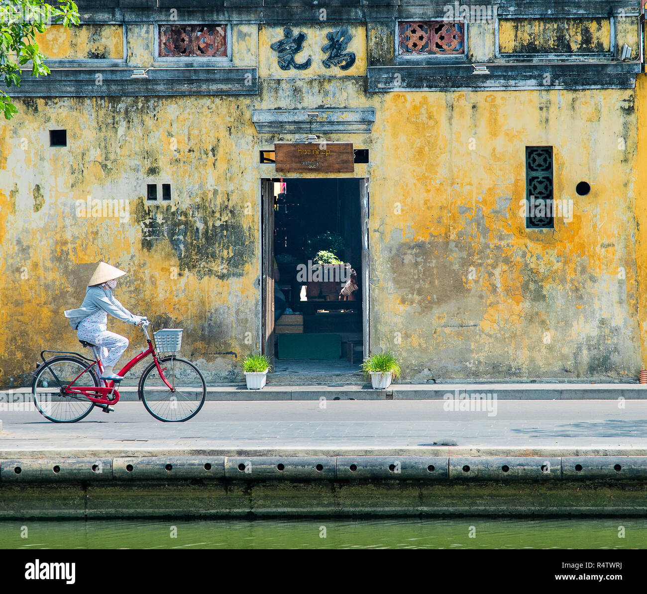 Hoi An une dame vietnamienne traditionnelle avec vélo dans la vieille ville de Hoi An au Vietnam. Banque D'Images