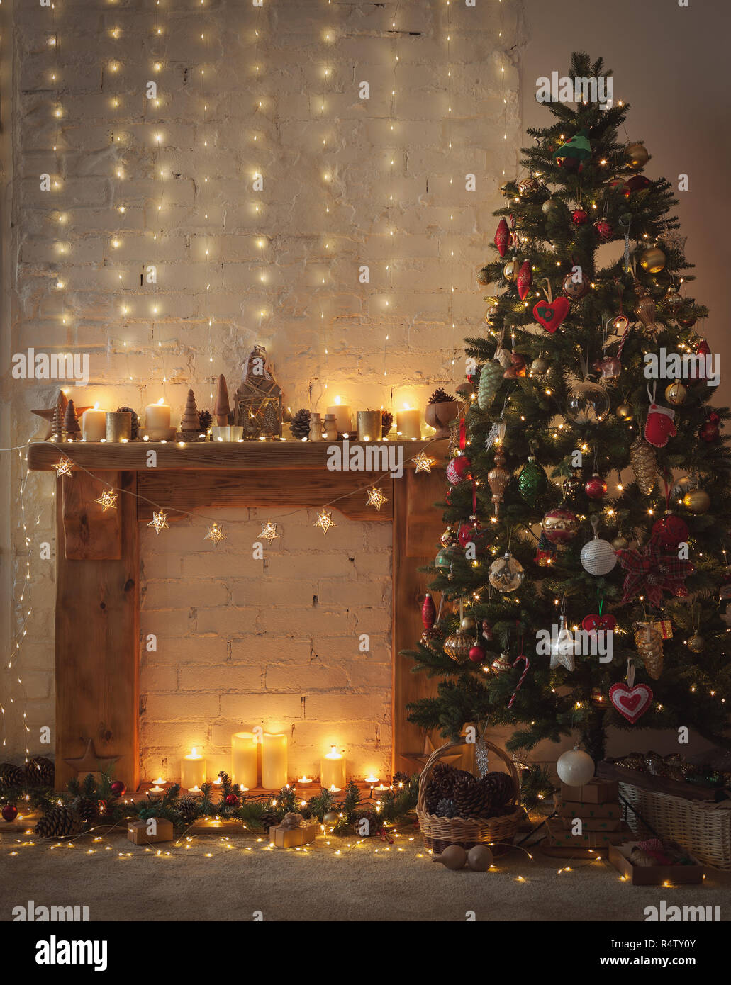 Beau Noël, cheminée avec feu de cheminée en bois surround, illuminé de l'arbre de Noël décoré avec des ornements et des babioles, stars, Chris Banque D'Images