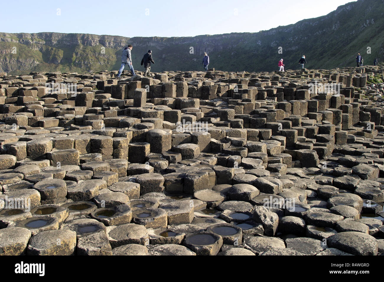 Les visiteurs et les touristes se promener sur la Chaussée des Géants, en Irlande du Nord, qui est 40 000 colonnes de basalte, enclenchement, qui a émergé après une énorme éruption volcanique, il y a de nombreuses années. C'est un site du patrimoine mondial de l'UNESCO et est visité par des milliers de personnes chaque année. Banque D'Images